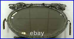 Miroir Art Déco ovale à patine argenté, surmonté de 2 dragons ou gargouilles Miroir Art Déco ovale à patine argenté, surmonté de 2 dragons ou gargouilles