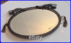 Miroir Art Déco ovale à patine argenté, surmonté de 2 dragons ou gargouilles Miroir Art Déco ovale à patine argenté, surmonté de 2 dragons ou gargouilles